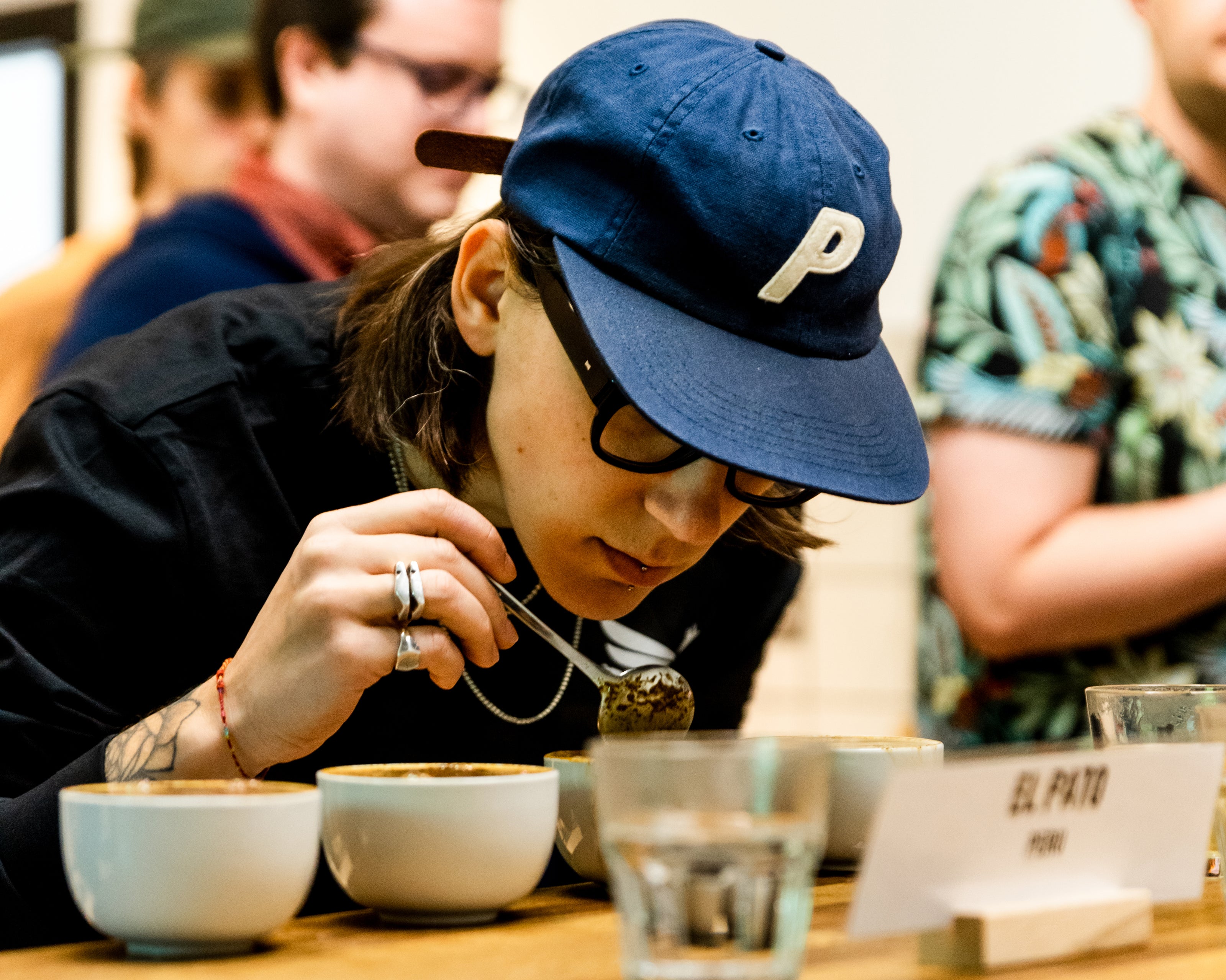 A person smelling coffee during a coffee cupping.